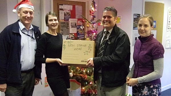 Three Brighton & Hove City Council workers present New Steine Mews hostel manager Karen Leenders with some donated gifts for Christmas