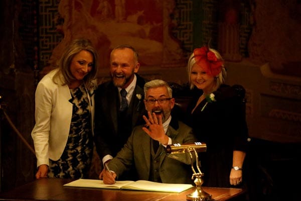 The first same sex marriage in England and Wales took place in Brighton at just after midnight on 29th Mar 2014 , between Andrew Wale (seated) and Neil Allard, at the Pavilion, Brighton - signing the register