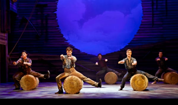 Ashley Day as Curly (centre) with the cast of the National tour of OKLAHOMA! credit Pamela Raith