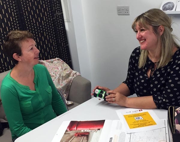 Lucy shows Marny, who has experience homelessness, how to use the single-use camera